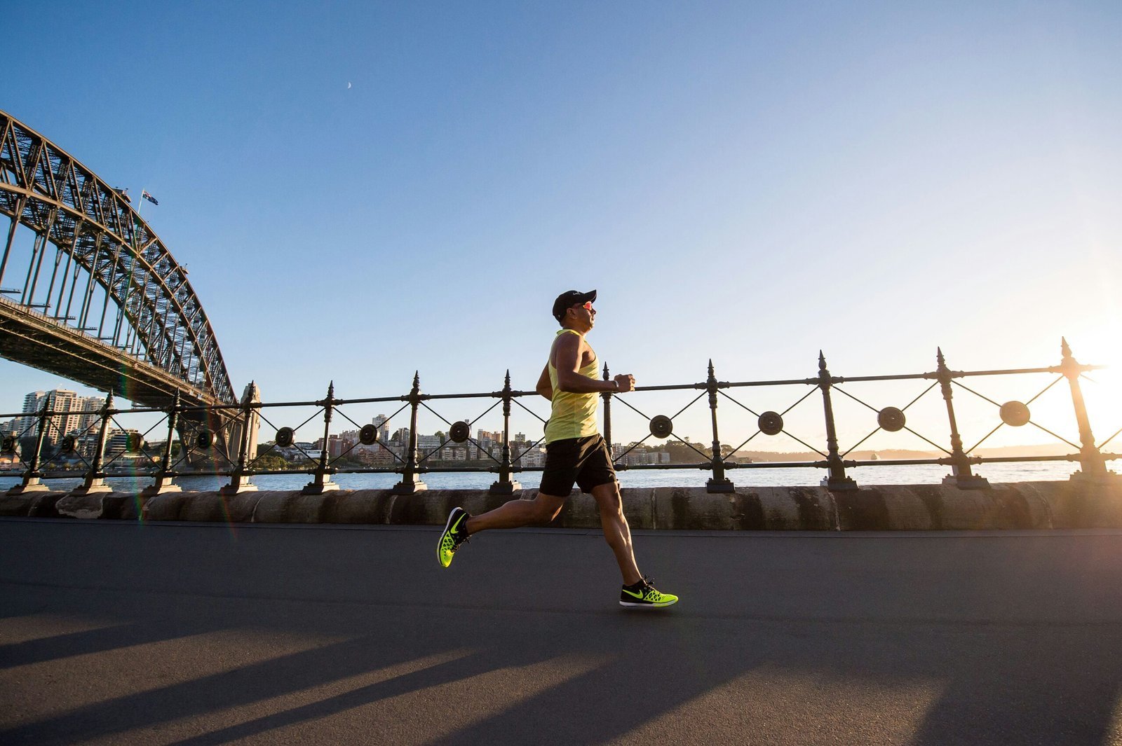 man in yellow tank top running near shore